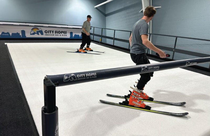 instructor and student at city slopes with logo in background