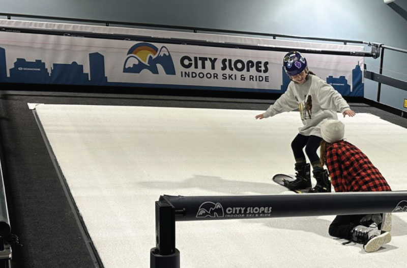 young student and instructor on branded ski ride machine